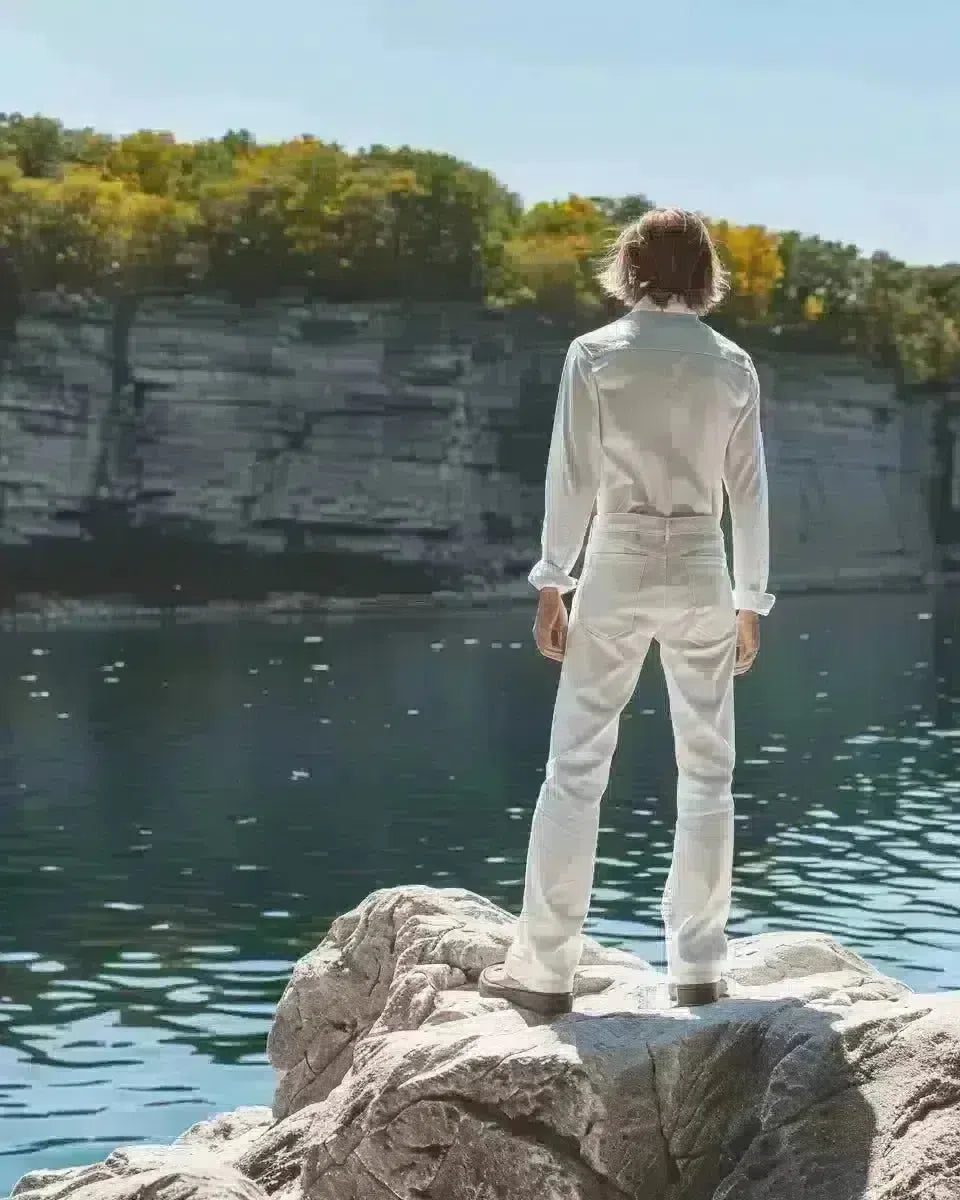 Man in white jeans by Ontario lake, embodying spring fashion. Spring season.