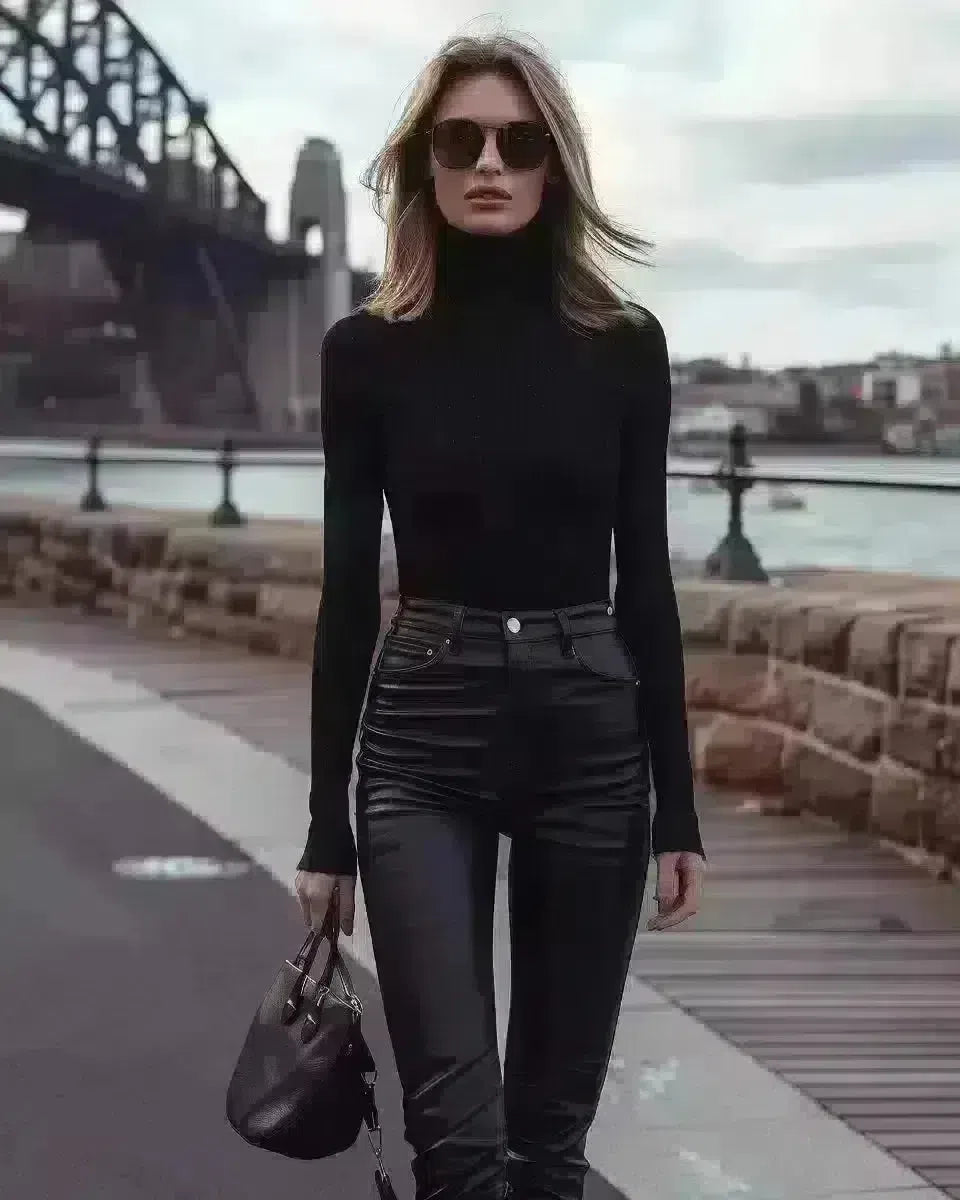 Elegant woman in black coated jeans by Sydney Harbour Bridge. Spring season.