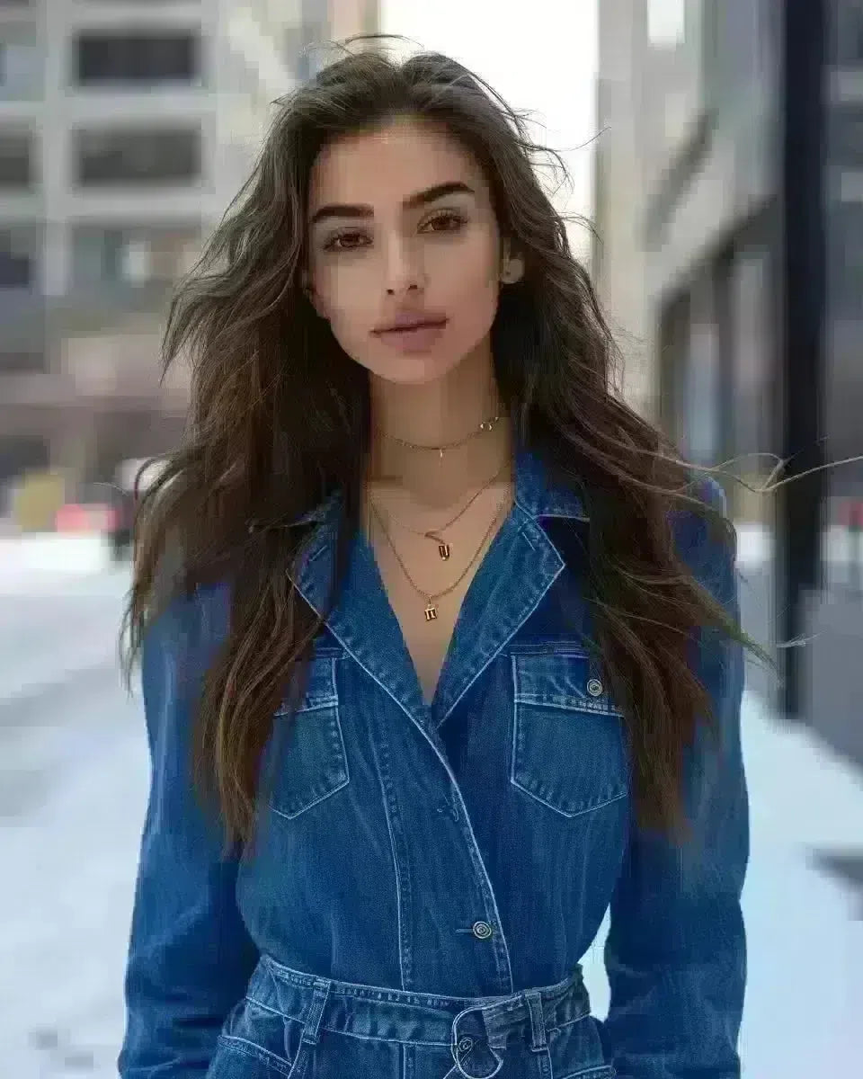 Middle Eastern woman in blue denim jumpsuit, confident stance, outdoor city background. Winter  season.