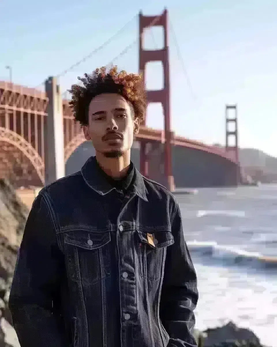 Diverse male model in classic indigo denim jumpsuit, Golden Gate Bridge backdrop. Winter  season.