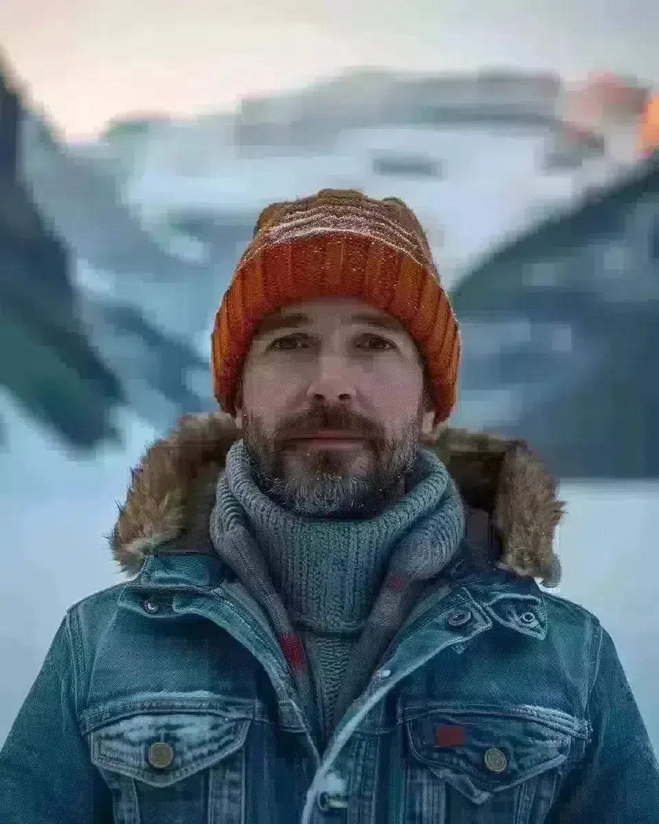 Man in denim jacket, brass buttons, sunset at Lake Louise. Winter  season.