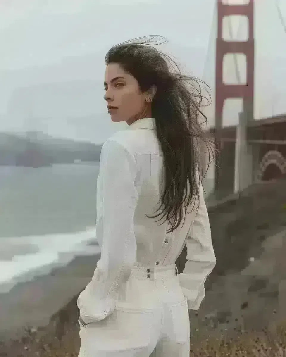 White denim jumpsuit on a woman before the Golden Gate Bridge. Winter  season.
