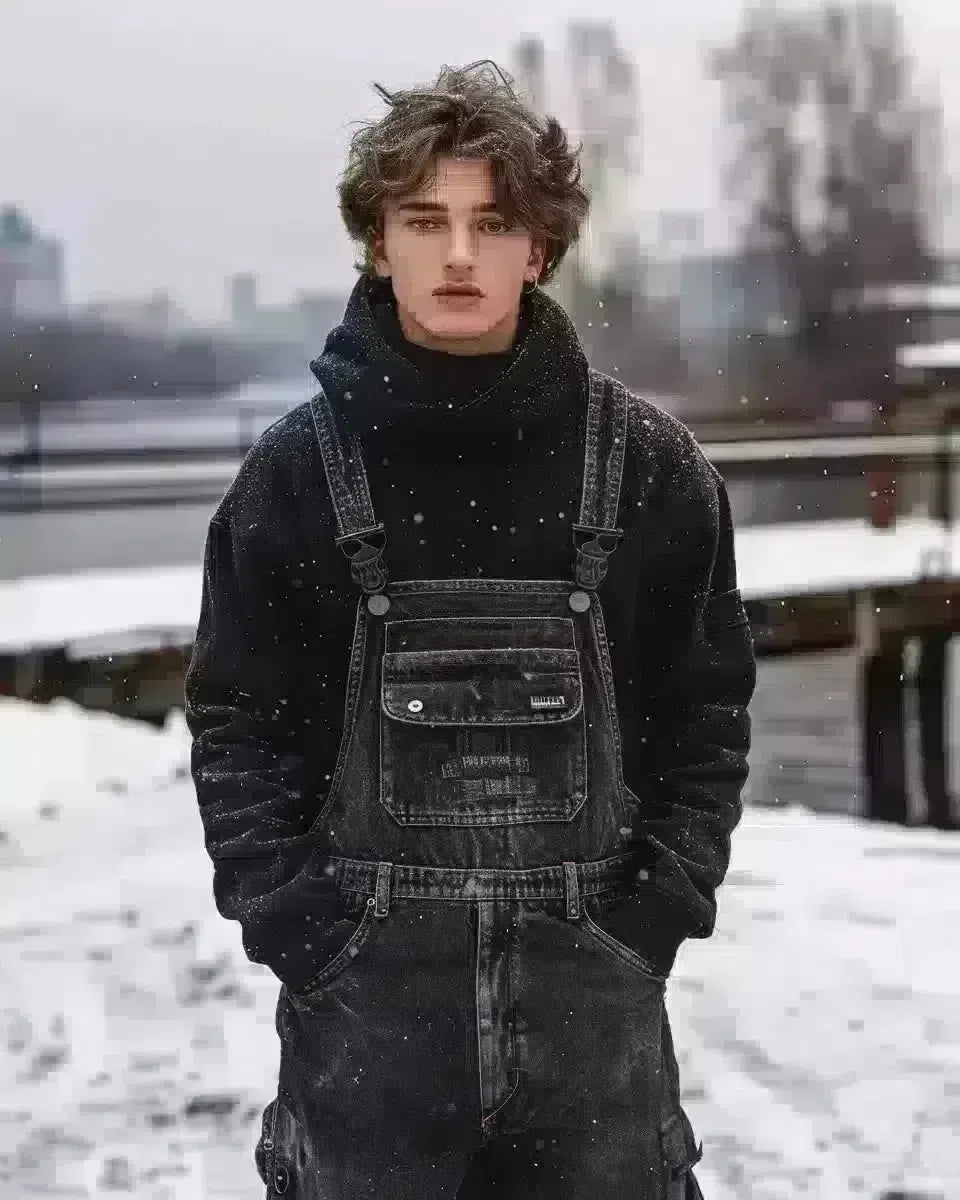 Model in men's long sleeve denim overalls, urban outdoor backdrop, reflecting modern fashion. Late Winter  season.