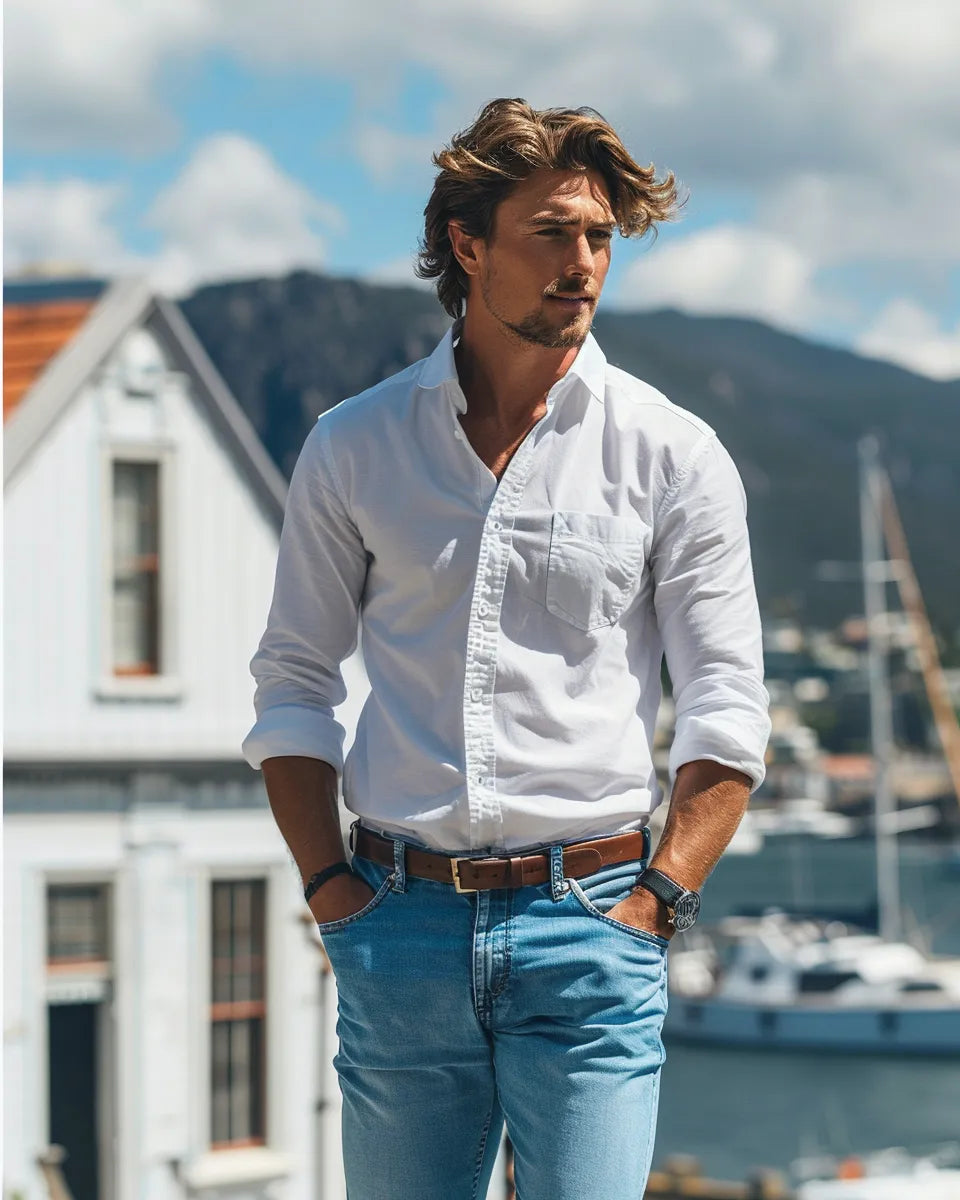 Men's high-waisted jeans styled for spring: light, breathable fabrics, bright colors, paired with crisp white shirts or polos. Summer season. European male. Port Arthur Historic Site, Tasmania city background.