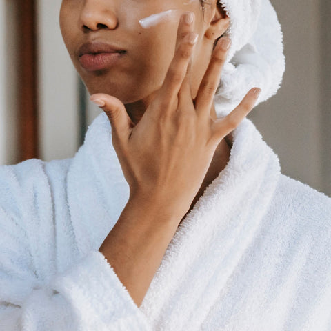 A woman applying a wrinkle cream to her face, showing the correct application method.
