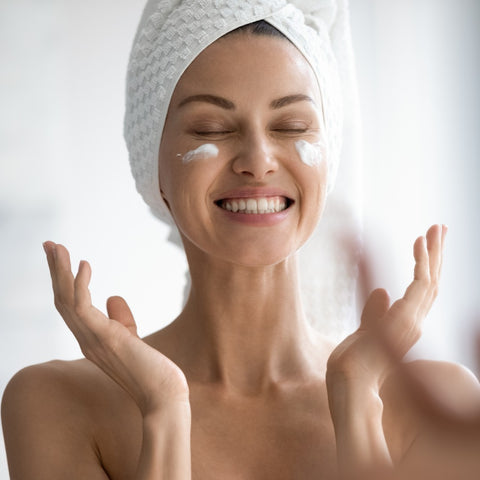 A woman looking happy and confident with her smooth, wrinkle-free skin.