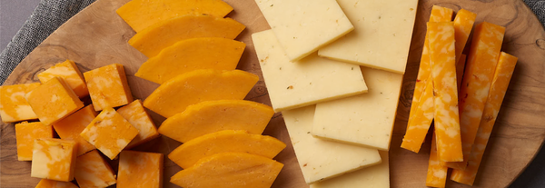 Images of cut cheese on a board