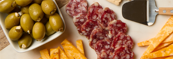 Images of olives and meats on cheese board
