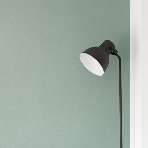 Mur vert pastel et lampe.