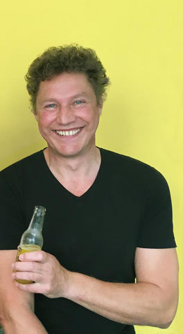 Peter Kowalsky mit schwarzem Tshirt und dem Getränk Flash in der Hand