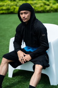 Model Samuel Loh in streetwear styled. Wears black cropped hoodie with match harem shorts. Wearing Finix teal blue cap sleeve t-shirt underneath