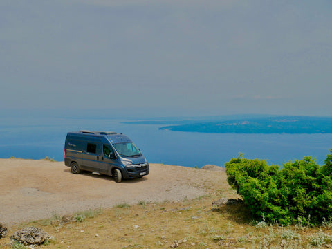 Kastenwagen vor blauem Meer 