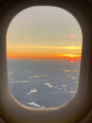 Blick aus Flugzeugfenster auf Sonnenuntergang 