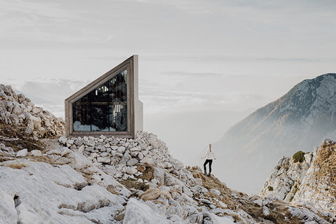 Landschaft mit gläserner Berghütte und Frau