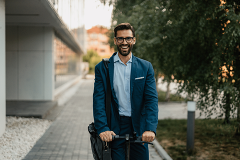 Man smiling on electric scooter - happy to take care of himself