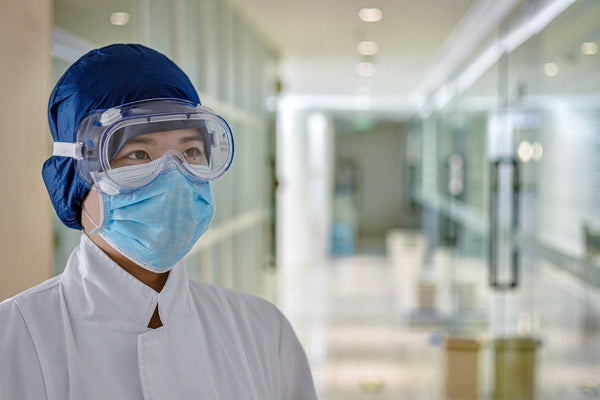 man in hospital white dress wearing blue mask