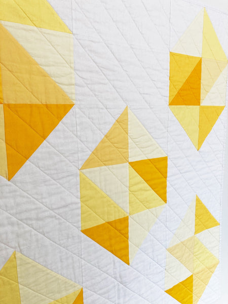 Facets modern gemstone quilt pattern by Monika Henry of Penny Spool Quilts - Quilt featuring modern, simplified yellow gemstones on white background.