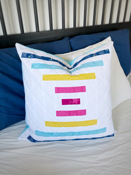 Raise the Bar beginner-friendly modern big block quilt pattern, courthouse steps quilt pattern by Penny Spool Quilts - pillow sample in pink, mustard and blue on white background