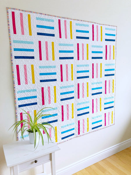 Bar Code quilt pattern by Monika Henry of Penny Spool Quilts - pink, yellow and blue bars on white background, square throw