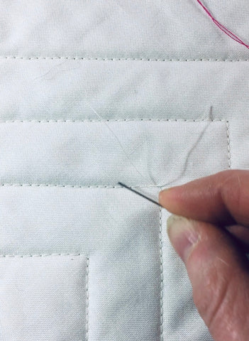 How to bury short threads, a quilting tutorial by Penny Spool Quilts - knotting the threads