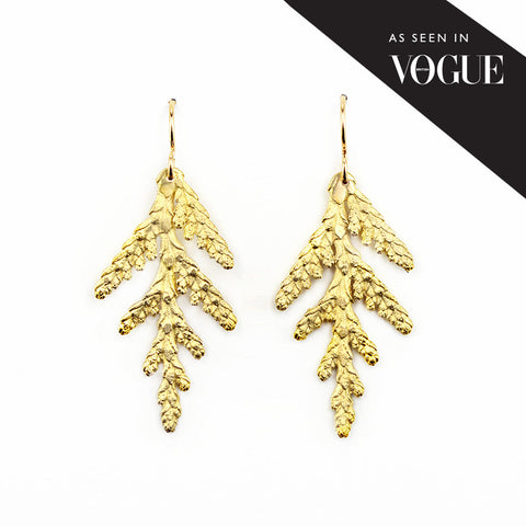 "As see in Vogue" golden bronze cedar earrings on white background