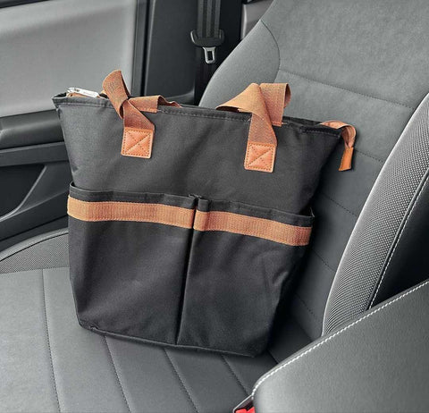 A tote handbag on the passenger seat of the car.