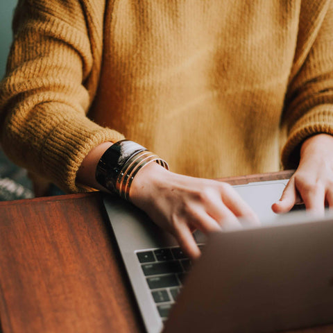 A man in yellow working at a computer.