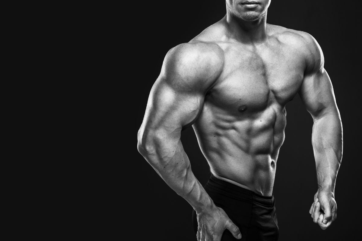 Black & white photo of a bodybuilder flexing.