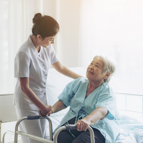 Elderly Women with a walker being helped by a nurse