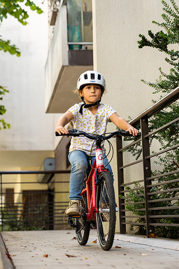 Enfant en ville sur un vélo 20 pouces rouge Gibus Cycles