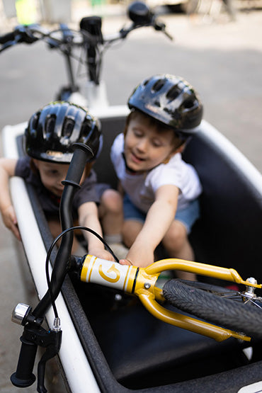 2 enfants dans un vélo cargo avec une draisienne 12 pouces