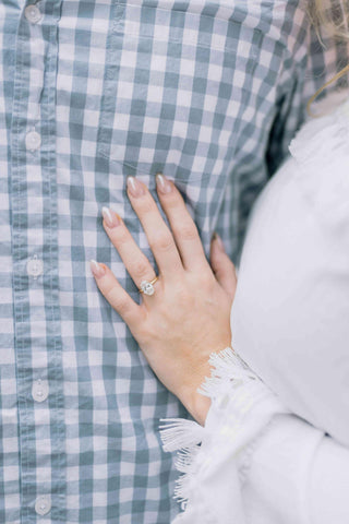 A woman resting her hand on her partners chest showcasing her engagement ring