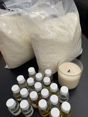 two bags of candle wax, many bottles of fragrance oil next to it and a filled candle in a clear jar