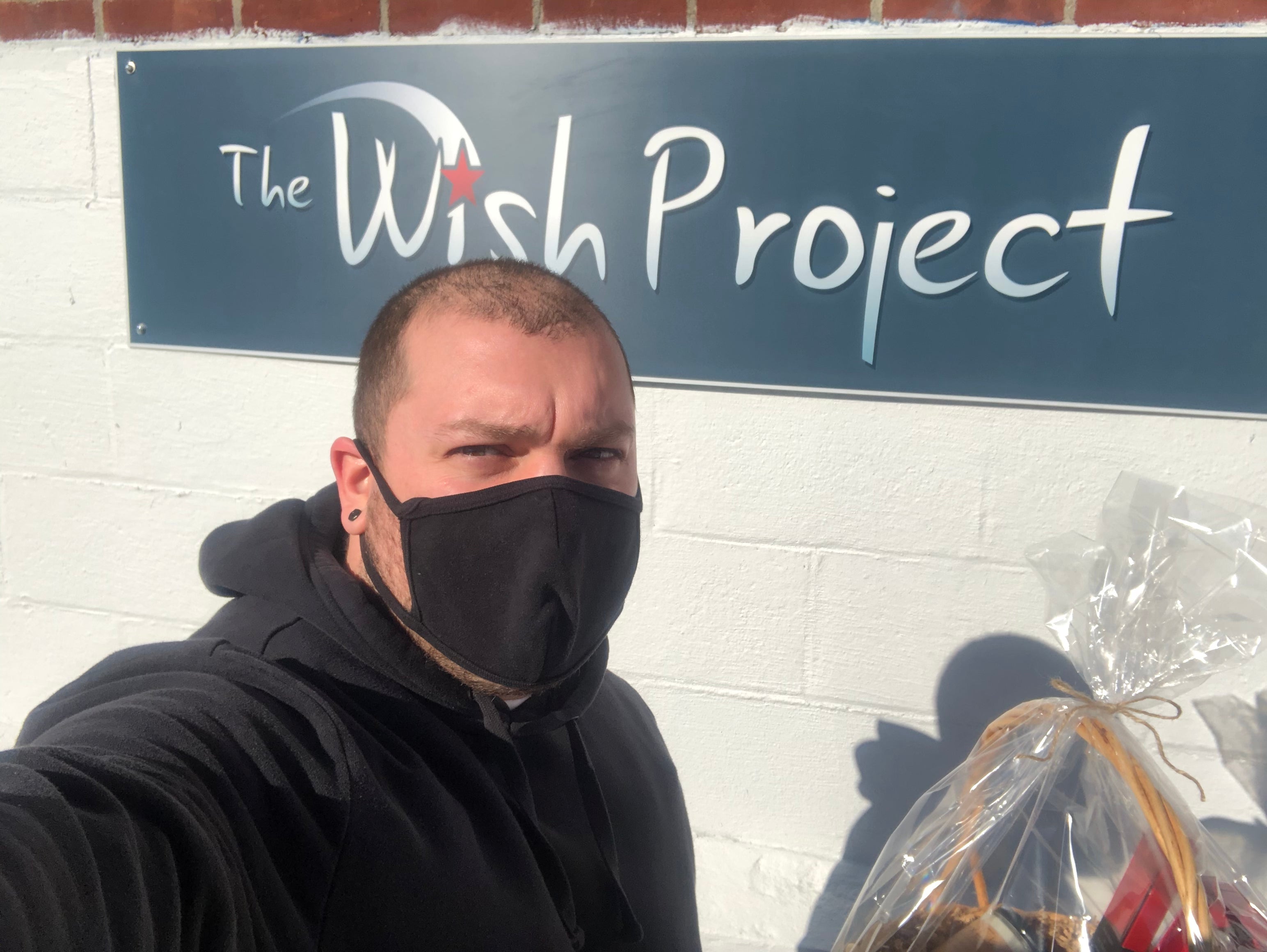 Fern x Flow owner, Joe Wing, in front of The Wish Project's sign outside their Chelmsford, MA location.