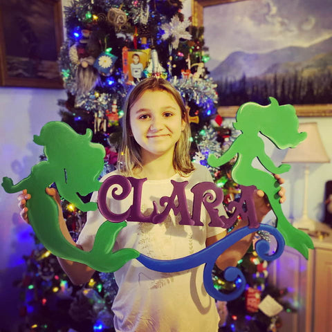 Girl Poses with Custom Name Sign in front of Christmas Tree