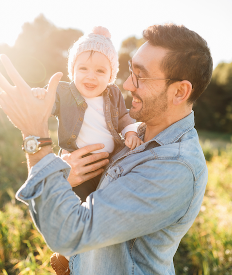 man with blue jacket waving with baby girl