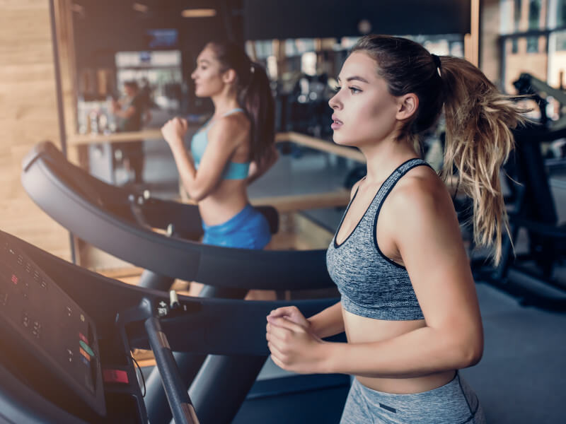 Women run on treadmill in gym