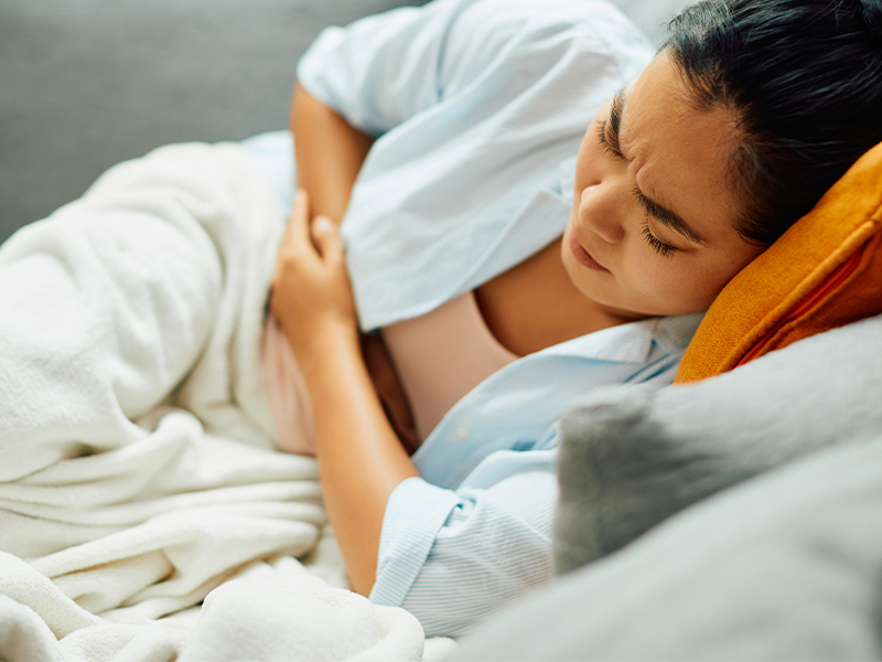 Woman laying on bed sick