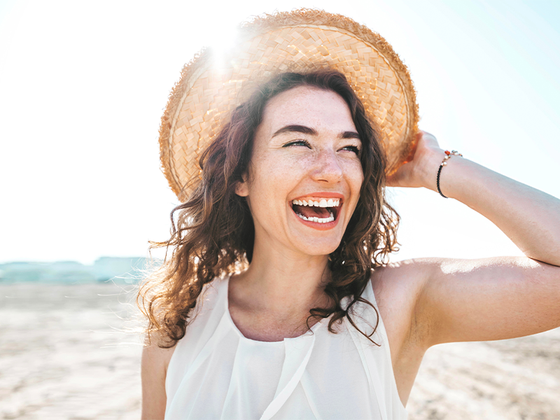 Smiling lady who has taken phenQ in a sunhat