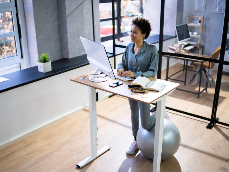 Woman working at standing desk to burn calories