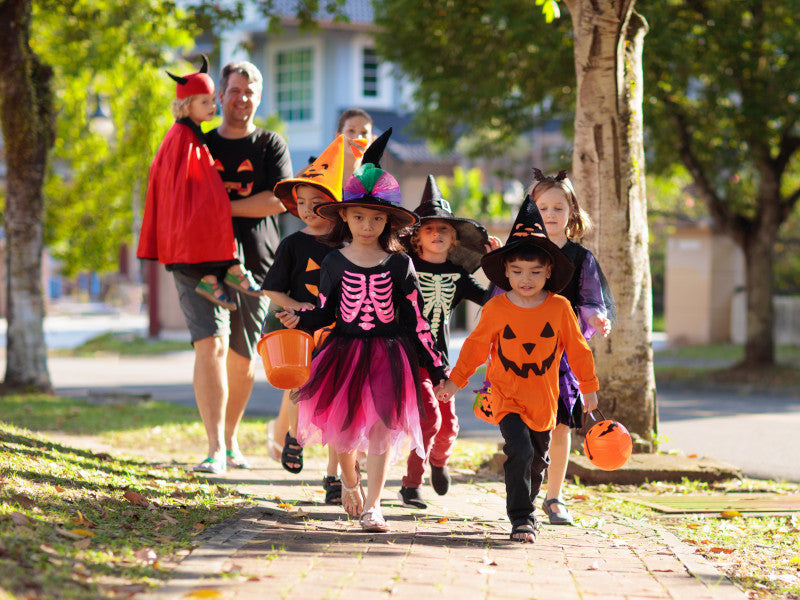 Couple walking with trick or treating kids