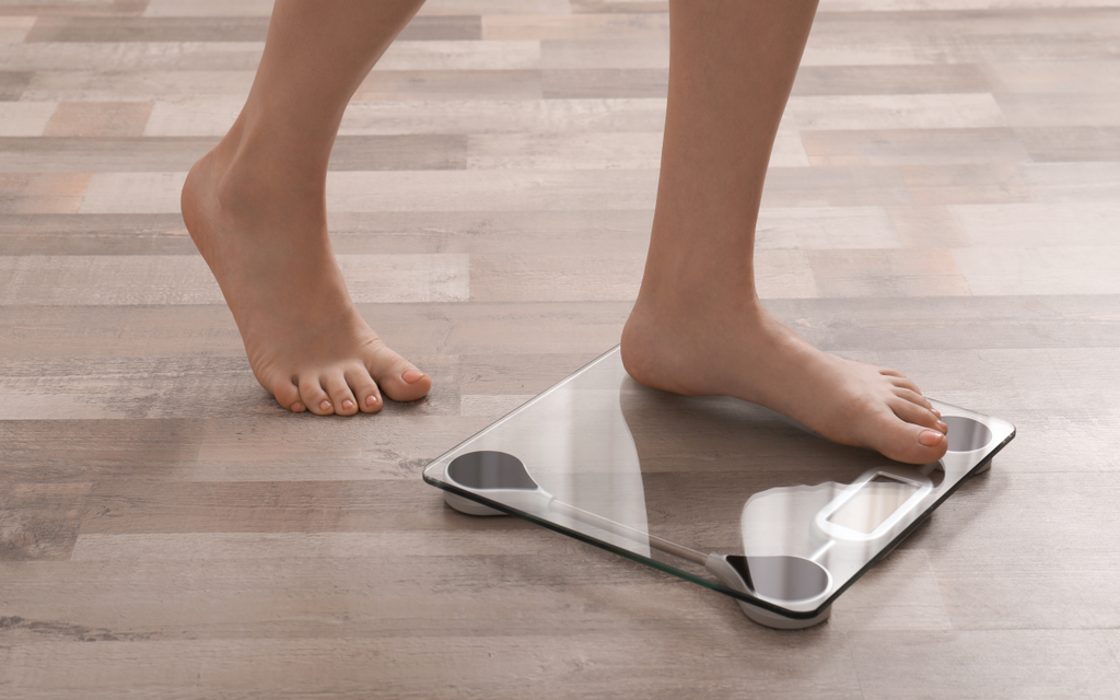 Woman weighing herself on scales