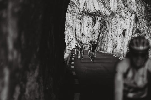 A group of cyclists riding along Gorge de la Nesque in France.