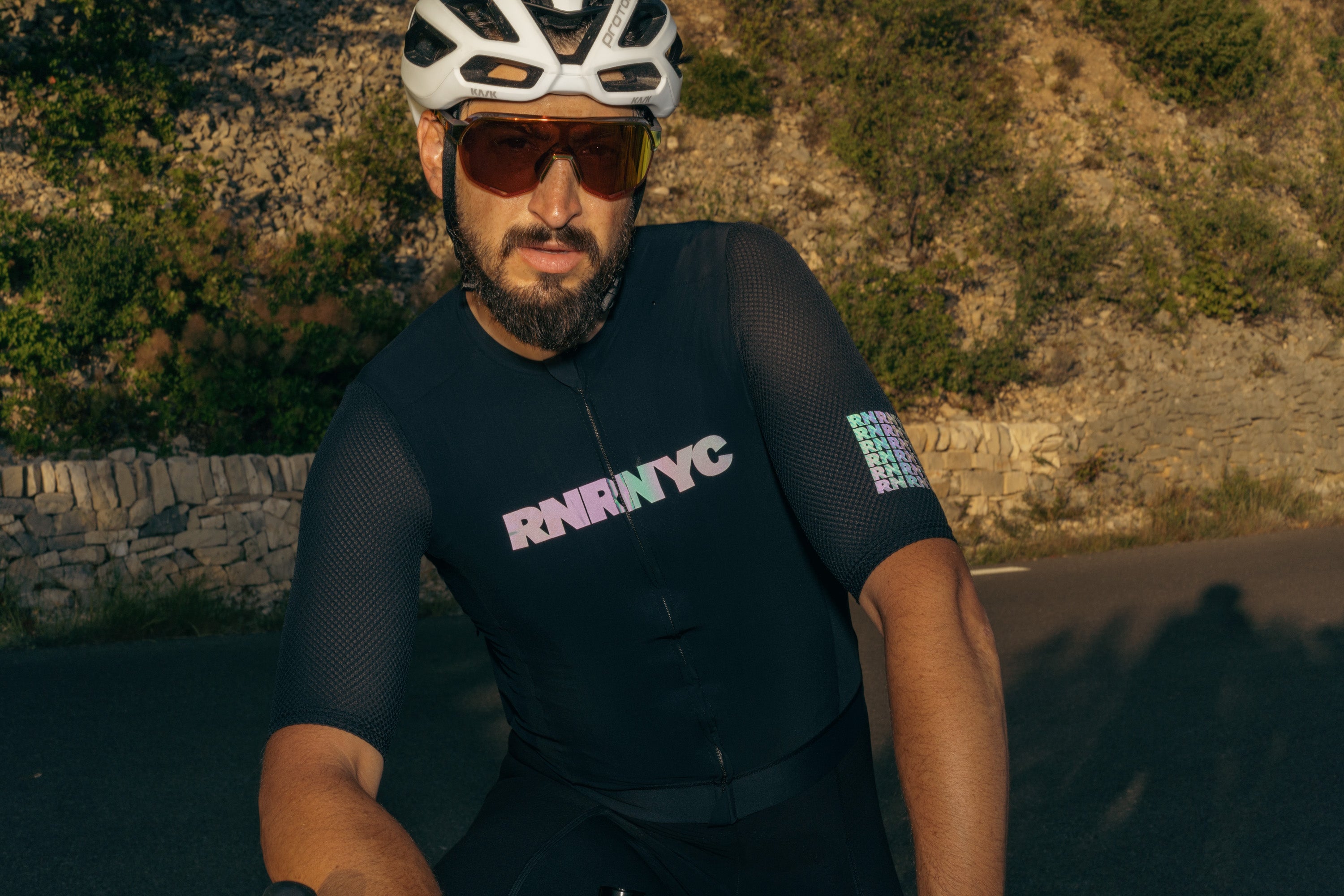 A cyclist poses in the RUBBER N' ROAD RNRNYC™ REVERB Race Jersey.
