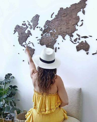 Woman pointing at her 3D Wooden World Map in Dark Walnut Color