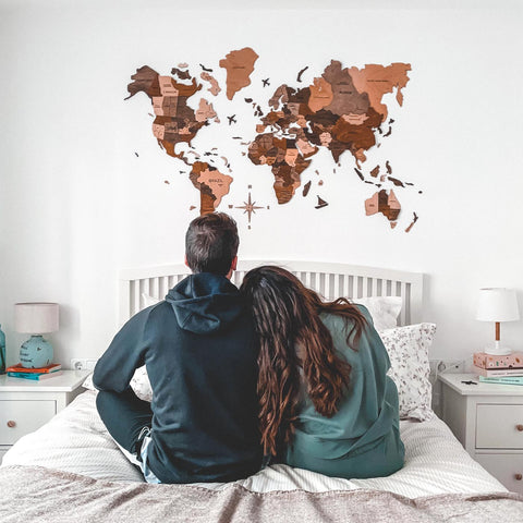 Ein Paar, das seine 3D Weltkarte Holz in Multicolor betrachtet