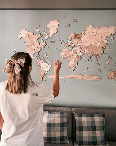 Woman Pointing at her 3D Wooden World Map