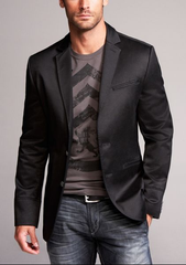 body shot of man wearing printed gray and black t-shirt beneath a black suit jacket