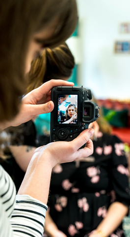 Photographer taking a picture of Corinne getting her make up done