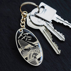 Enamel key ring in black and gold with a beautiful design featuring Newcastle & Gateshead landmarks including flying angels of the north